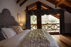 a bedroom with a bed and a large window at Intiterra Apart Hotel Villas in Urubamba