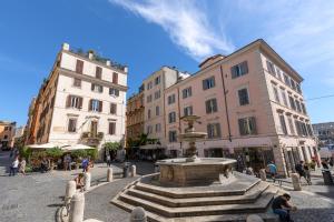 a fountain in the middle of a street with buildings at Rome As You Feel - Monti Apartment in Rome