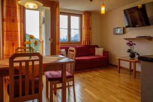 ein Wohnzimmer mit einem Tisch und einem roten Sofa in der Unterkunft Gästehaus Hausberger in Schruns-Tschagguns