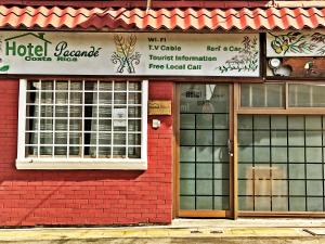 a red brick building with a hotel room at Hotel Pacande B&B in Alajuela