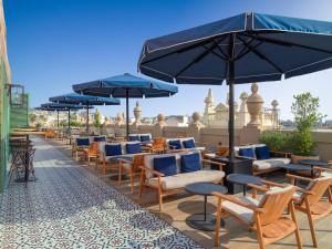 a patio area with tables, chairs and umbrellas at H10 Madison 4* Sup in Barcelona