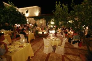 a group of tables in a restaurant at night at Hotel Rural Posada del Moro in Cazalla de la Sierra +48 photos