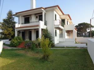 a white house with a green yard at MORADIA-BARCO DO PORTO in Viana do Castelo