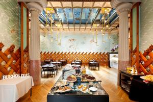 un ristorante con tavolo e cibo sopra di Hotel España Ramblas a Barcellona