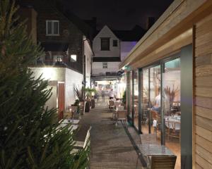 an outdoor patio with tables and chairs at night at Kings Arms Hotel in Berkhamsted