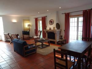 a living room with a table and a fireplace at MORADIA-BARCO DO PORTO in Viana do Castelo