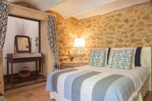 a bedroom with a bed and a table with a mirror at El Encinar de Arta in Artá +60 photos