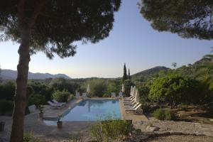 a swimming pool in a villa with mountains in the background at El Encinar de Arta in Artá