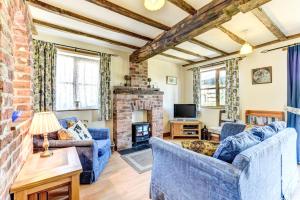 a living room with blue furniture and a brick fireplace at Bwthyn Banw in Meifod
