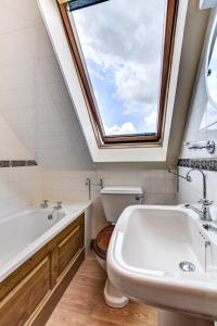 a bathroom with a window and a tub and a sink at Bwthyn Banw in Meifod +14 photos