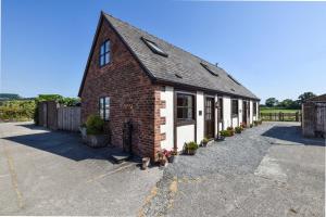 a brick building with white doors and windows at Bwthyn Banw in Meifod