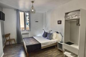 1 dormitorio con 1 cama, 1 silla y 1 ventana en Les Appartements d'Edmond St Sebastien, en Marsella