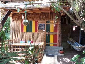 una casa con tetto di paglia e panchina di fronte di Chami's Place a Hikkaduwa