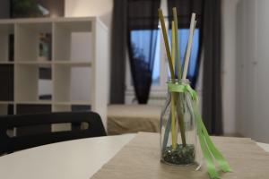 a glass vase with bamboo sticks in it on a table at Aliska's home in Guidonia