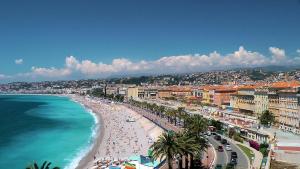 een uitzicht op een strand met mensen en de oceaan bij Nestor&Jeeves - PALAIS RENOIR - By sea - Free parking in Nice