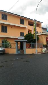 un edificio giallo con un cartello davanti di B&B Madau a Samughèo