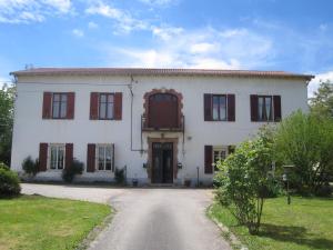 ein großes weißes Haus mit roten Rollläden in der Unterkunft Gîte Chanay 80 m2 Tournus 2 chambres in Tournus