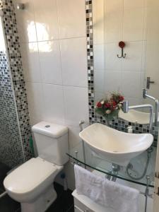 y baño con aseo y lavamanos. en Apartamento Confortável Guarujá en Guarujá