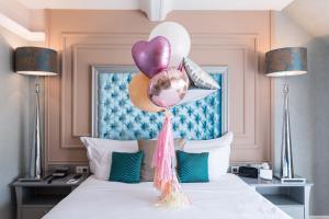 a bedroom with a bed with balloons on it at Aria Hotel Budapest by Library Hotel Collection in Budapest