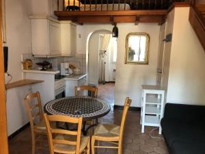 Maison de pêcheur à Porquerolles في بوركيرول: مطبخ وغرفة طعام مع طاولة وكراسي