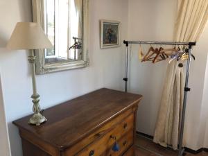 Cette chambre comprend une commode avec une lampe et un miroir. dans l'établissement Maison de pêcheur à Porquerolles, à Porquerolles
