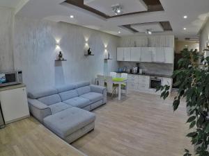 a living room with a couch and a kitchen at Apartment on Dragomirova in Kyiv
