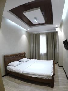 a bedroom with a bed with a coffered ceiling at Apartment on Dragomirova in Kyiv