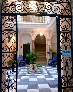 uma entrada para um edifício com piso xadrez em Pensión Cádiz em Cádiz