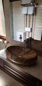 a bathroom with a large wooden sink on a counter at Vila Dante Boutique Hotel in Tushemisht