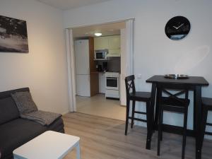 salon z kanapą i stołem oraz kuchnia w obiekcie Apartment Oulu station w mieście Oulu