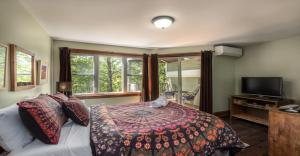 1 dormitorio con 1 cama y TV de pantalla plana en Le Boisé by Rendez-Vous Mont-Tremblant en Mont-Tremblant