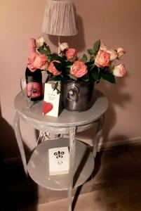 a table with a vase of flowers and a lamp at Le Clos des Aramons in Bernis