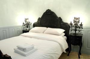 ein Schlafzimmer mit einem großen weißen Bett mit zwei Nachttischen in der Unterkunft Tennyson Retreat in Lincoln