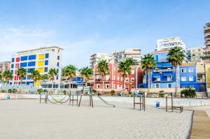 a playground on the beach in front of buildings at The Sailor House in Villajoyosa