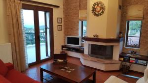 a living room with a fireplace and a tv at Villa Politimi at Aegina in Mesagrós