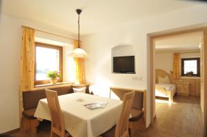 a dining room with a white table and chairs at Tomasoethof in Castelrotto