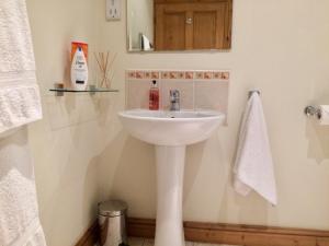 a bathroom with a white sink and a mirror at The Cottage in Belford