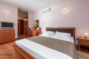 a bedroom with a large bed and a flat screen tv at Villa Nora Hvar in Hvar