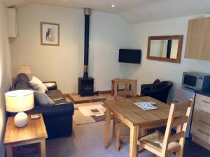 een woonkamer met een bank en een tafel met een fornuis bij The Cottage in Belford