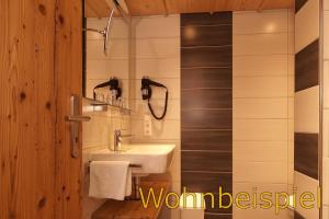 a bathroom with a white sink and a mirror at Panorama Hotel Kaserer in Fischen