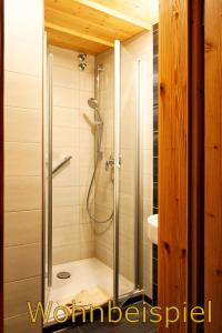 um chuveiro com uma porta de vidro na casa de banho em Panorama Hotel Kaserer em Fischen