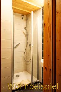 a shower with a glass door in a bathroom at Panorama Hotel Kaserer in Fischen