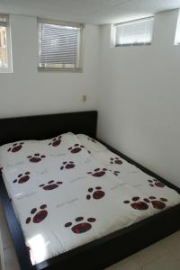 Una cama en un dormitorio con una colcha con flores. en Continentaiz Appartement, en Zandvoort