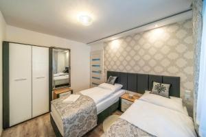 a small bedroom with two beds and a mirror at Apartament Glamour in Biały Dunajec