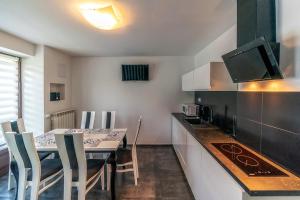 a kitchen with a table with chairs and a counter top at Apartament Glamour in Biały Dunajec
