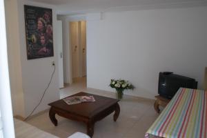 een woonkamer met een salontafel en een televisie bij Continentaiz Appartement in Zandvoort