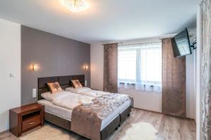 a bedroom with a large bed and a flat screen tv at Apartament Glamour in Biały Dunajec