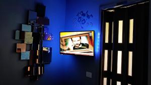 a tv on a blue wall in a room at Inna Best House in Milan