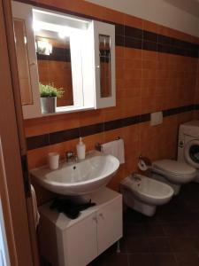 Un baño con lavabo, inodoro y espejo. en Rovelli Room, en Bérgamo