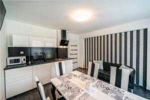 a kitchen and a dining room with a table at Apartament Glamour in Biały Dunajec